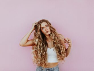 woman curly hair pink background