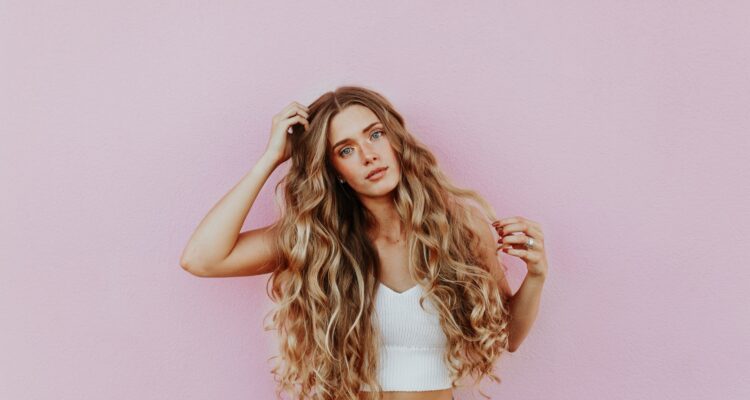 woman curly hair pink background