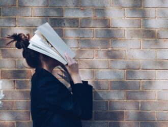 Girl with book over face