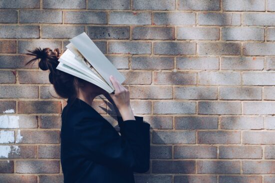 Girl with book over face