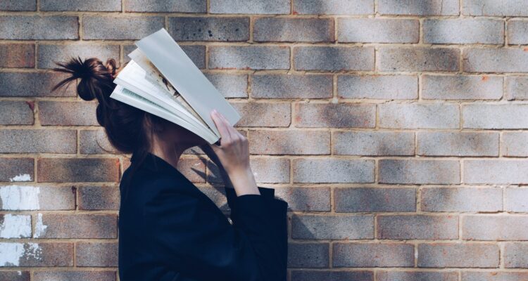 Girl with book over face